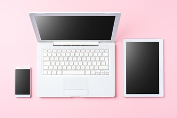 Technology background with modern white computer, tablet and smart phone on pink background