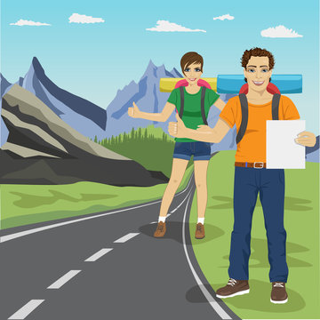 Young man and woman hitchhiking on road in mountains