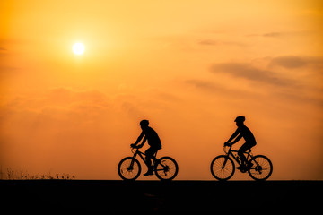 Silhouette of cyclist on sunset background