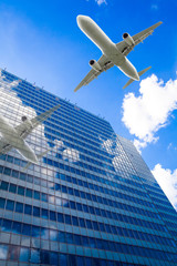 Fototapeta na wymiar Skyscrapers with a flying airplane against blue sky