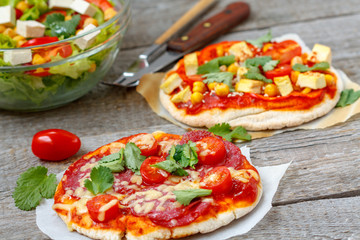 Homemade mini pizzas (meat and vegan) with vegetable salad.