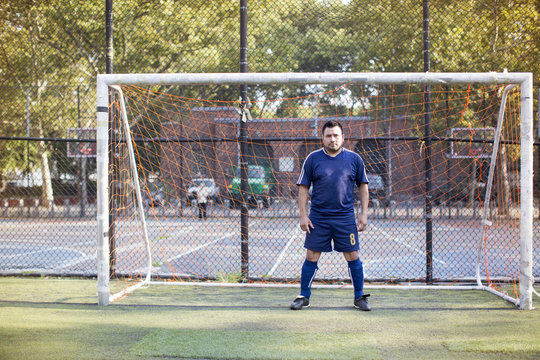 Portrait of a soccer player standing in front of goal