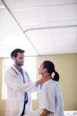 Obraz premium Doctor examining patients neck in hospital
