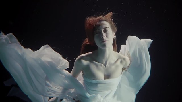 young woman swimming under the water