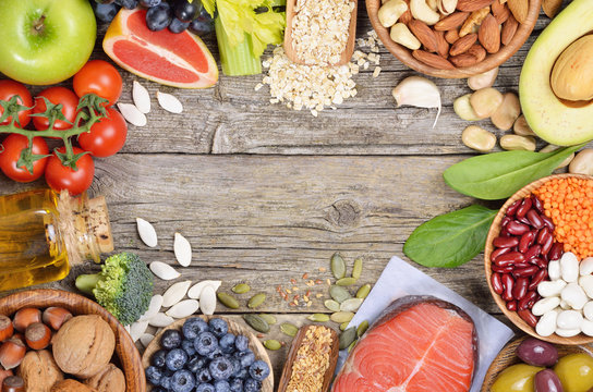 Healthy eating background. Different vegetables,nuts,oils and beeries on wooden table. Copyspace background. Top view.