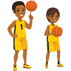 Young basketball African American children players standing with ball