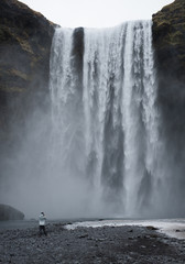 Traveler photographing Skogafoss Waterfall in Iceland