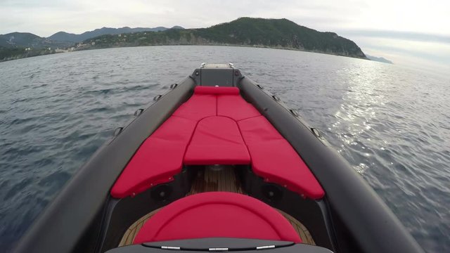 Red sofa on the bow of a sporty rubber boat navigating at full speed.