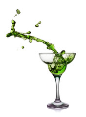 Splash in glass of a green alcoholic cocktail drink