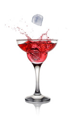 Splash in glass of a pink alcoholic cocktail drink with ice