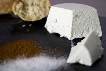 Ricotta cheese with sugar and cinnamon. Background: bread.