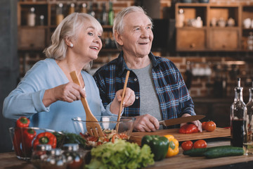 portrait of senior couple looking away while cooking together