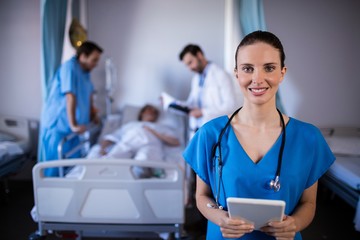 Portrait of smiling female doctor holding digital tablet