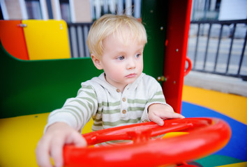 Cute toddler boy having fun on playground