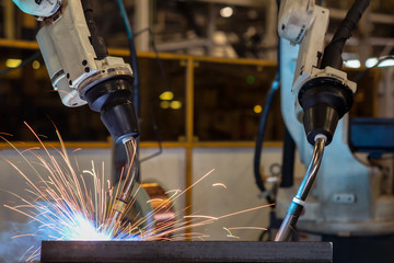 Close-up robots are welding in a car factory
