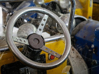 Fototapeta premium Abandoned electric toy's car with racing wheel and spider web, original fun ride background