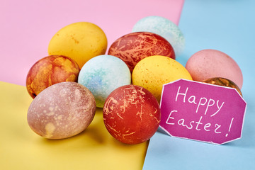 Greeting card and painted eggs. Paper with Happy Easter inscription.