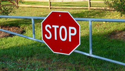 A stop sign on a metal gate.