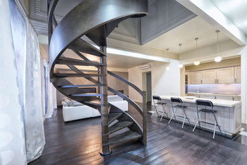 Russia,Moscow - modern living room interior. Duplex apartment with a stylish spiral staircase.