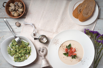 Soup puree with salmon and an omelette on the table copy space