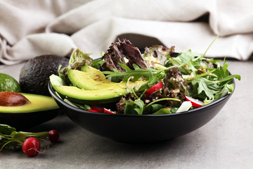 avocado, radish, sesame and arugula salad. Healthy vegan food. allergy-friendly, clean eating and raw diet.