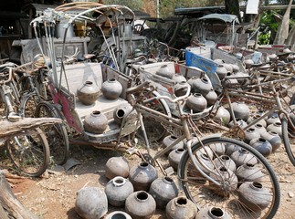 Old tricycles lined up on the ground with old jars, traditional samlor in thailand, vintage...