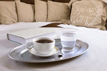 Coffee Cup with Book on Table with Sofa and Pillows in Background