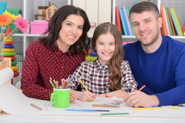 Parents with daughter draw together