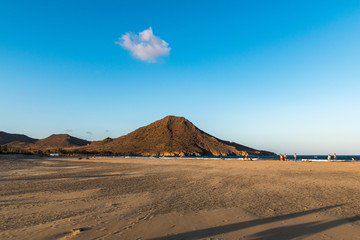 mountain on a beach on a blue sky day