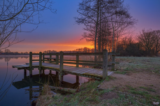 Morgens am Steg / Sonnenaufgang &uuml;ber dem Thielenburger See in Dannenberg (Landkreis L&uuml;chow - Dannenberg, Niedersachsen, Deutschland). Aufgenommen am 19. M&auml;rz 2017.