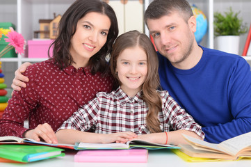 Parents helping daughter with lessons