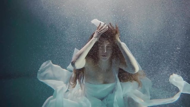 young woman swimming under the water