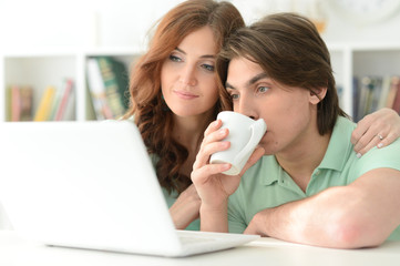 Beautiful young couple with a laptop