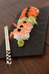 Nigiri sushi served with chopsticks in black stone slate