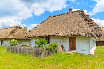Fototapeta na wymiar Old traditional house with straw roof in Tokarnia village on sunny spring day, Poland
