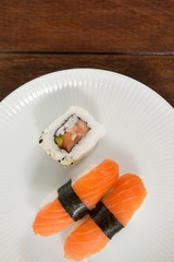 Nigiri and uramaki sushi served in white plate 