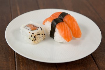 Nigiri and uramaki sushi served in white round plate