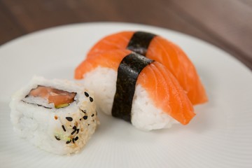 Nigiri and uramaki sushi served in white plate 