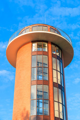 Lighthouse tower against blue sunny sky in Debki village, Baltic Sea, Poland