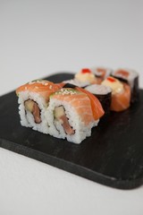Maki, uramaki and nigiri sushi served in black stone slate