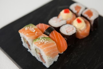 Maki, uramaki and nigiri sushi served in black stone slate