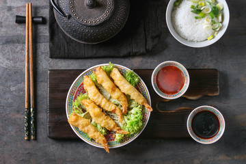 Fried tempura shrimps on lettuce salad with sauces. Served in traditional china plate with...