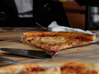  Piece of pizza on the table (on a wooden cutting board)