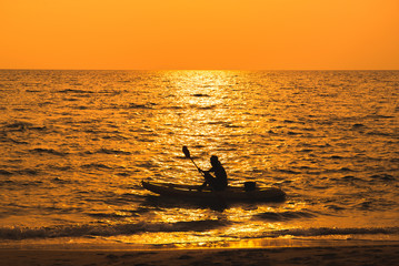 fisherman are boating on sea in sunset