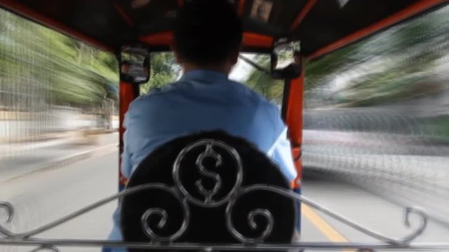 Tuk Tuk driving on street in Bangkok, Thailand. A popular three-wheeled taxi transport in Bangkok.