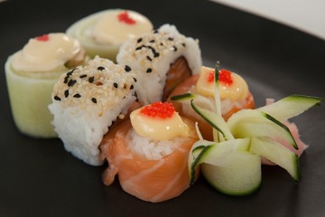 Uramaki and nigiri sushi served in black plate 