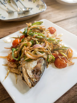 Salted fish fried topped with red onion, chili, tomato and herb
