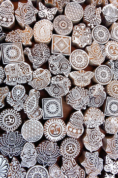 Symbols, leaves, sun, sea fish on wooden surface of mold blocks for traditional printing textile. Old design in India.