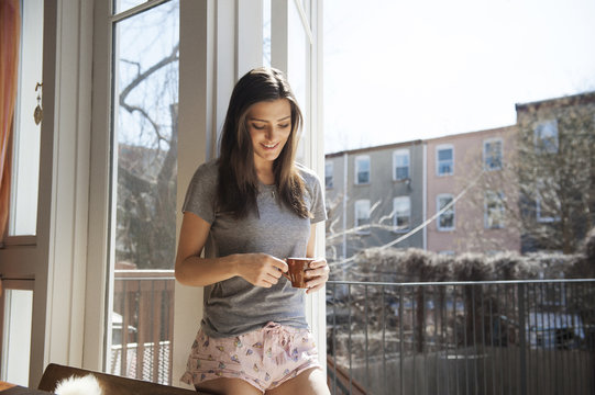 Woman standing with cup of coffee
