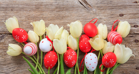 Easter eggs and tulips on wooden background and copy space